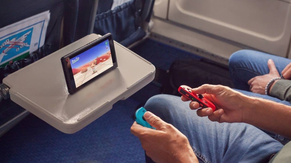 Eine Person nutzt eine Nintendo Switch während einer Zugfahrt.