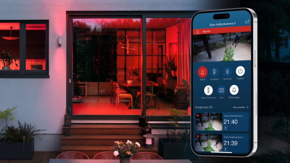 Die Bosch Smart Home Eyes Außenkamera II schlägt Alarm vor einem Wohnhaus und blinkt rot.