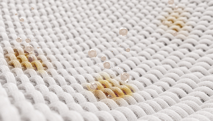 Nahaufnahme eines weißen Stoffes mit Flecken und Wassertropfen darauf.