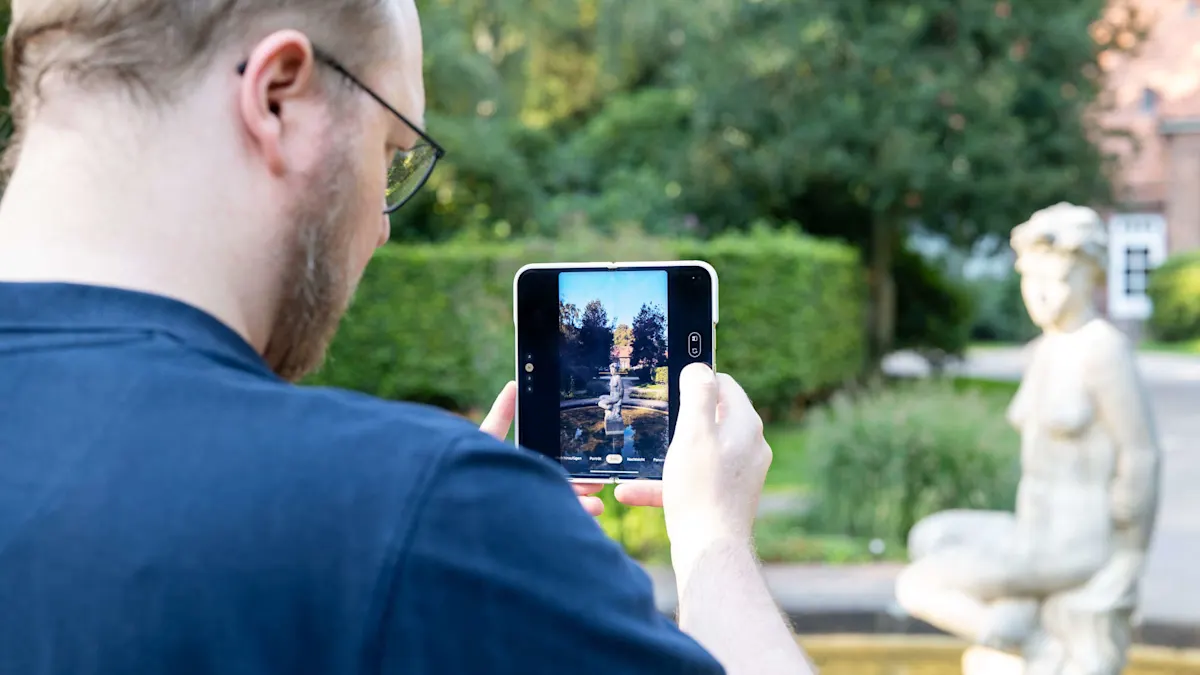 Eine Person macht ein Foto von einem Brunnen mit einer Statue mit einem Tablet im Freien.