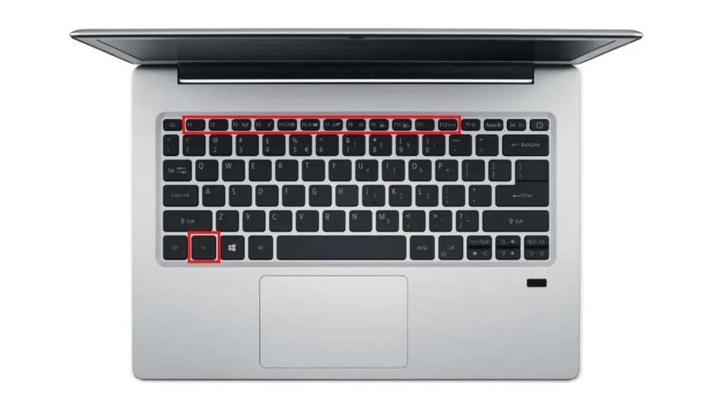 Draufsicht auf einen Laptop mit schwarzer Tastatur auf silbernem Gehäuse, wobei die Funktionstasten rot hervorgehoben sind.