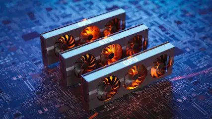Drei GPUs mit Lüftern liegen auf einer blauen Platine. Auf den grauen Gehäusen steht "GPU". Die Lüfter sind schwarz und orange.