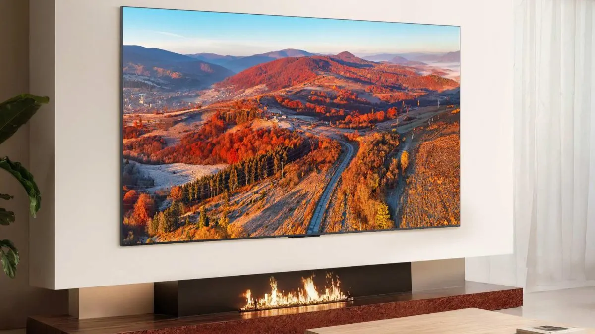 Der Fernseher TCL C8L hängt an einer Wohnzimmerwand.