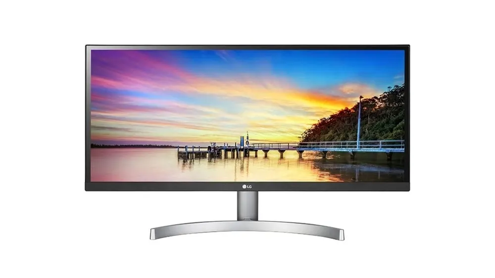 Ein schwarzer Computermonitor mit silbernem Standfuß zeigt einen Steg unter einem farbenfrohen Himmel.