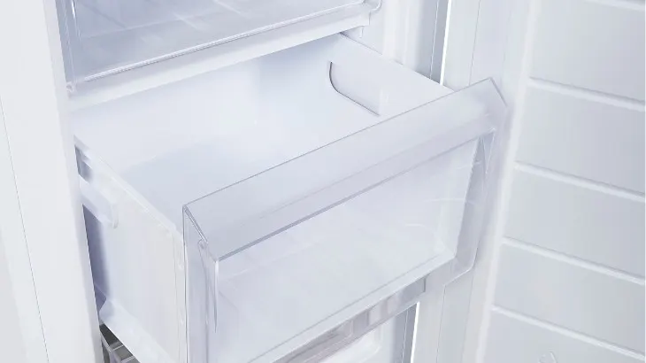 Ein weißer Kühlschrank mit einer herausgezogenen Schublade und Regalen an der Seite.