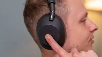 Alex steuert den Kopfhörer Sony WH-1000XM6 über das Touchbedienfeld auf der rechten Ohrmuschel.