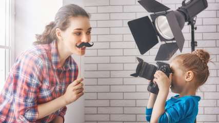 Ein Mädchen fotografiert ihre Mutter im Fotostudio.