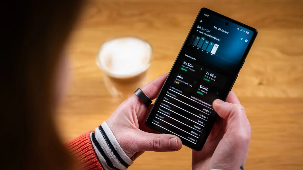 Franzi trägt den Ultrahuman Ring Air am linken Zeigefinger und schaut sich die Schlafauswertung in der Ultrahuman-App an.