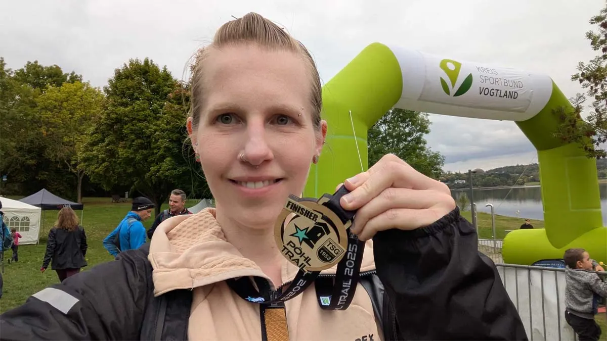 Franzi hält die Medaille des Trail Runs in die Kamera.