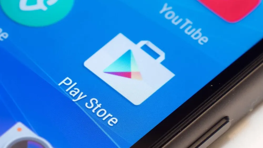 Nahaufnahme eines Smartphone-Bildschirms mit dem Play Store-Symbol auf blauem Hintergrund.