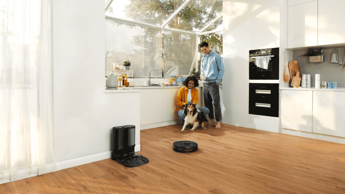 Man und Frau mit Hund stehen in der Küche neben ihnen ist ein ROBOROCK S7 MaxV Plus Saugroboter mit Station zu sehen