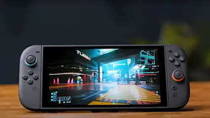 Die Nintendo Switch 2 steht mit eingeschaltetem Display auf einem Holztisch.