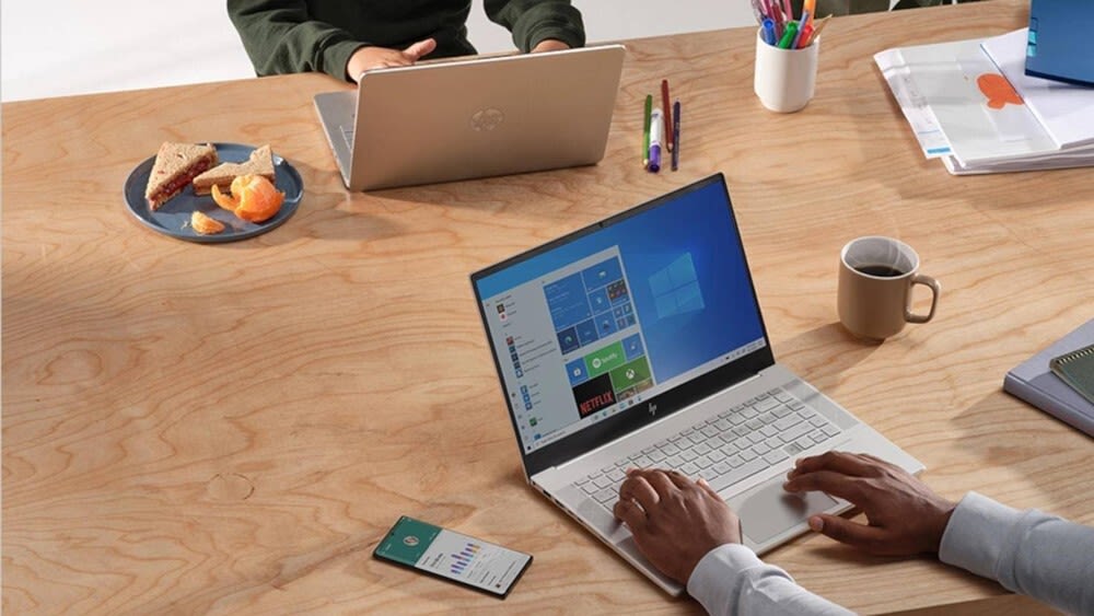 Zwei Männer sitzen mit ihren Laptops an einem Tisch
