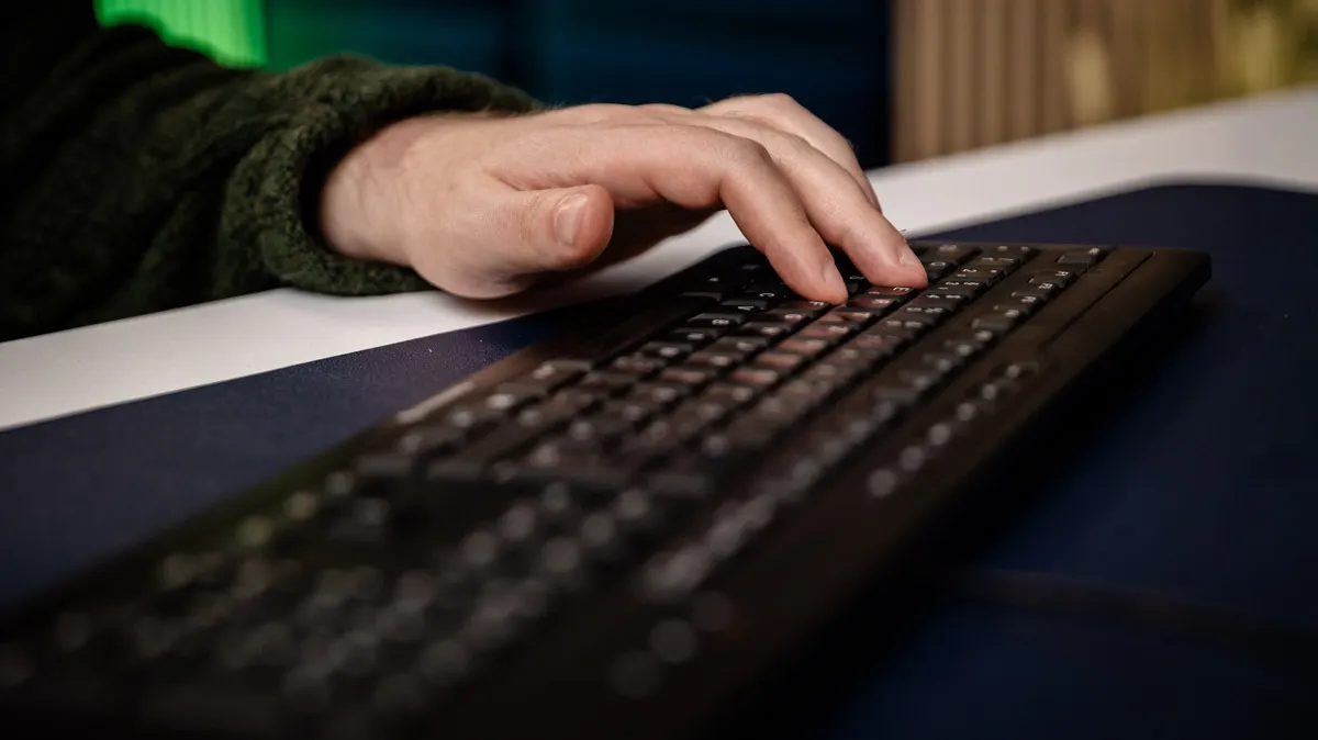 Eine Hand tippt auf einer Rubberdome-Tastatur.
