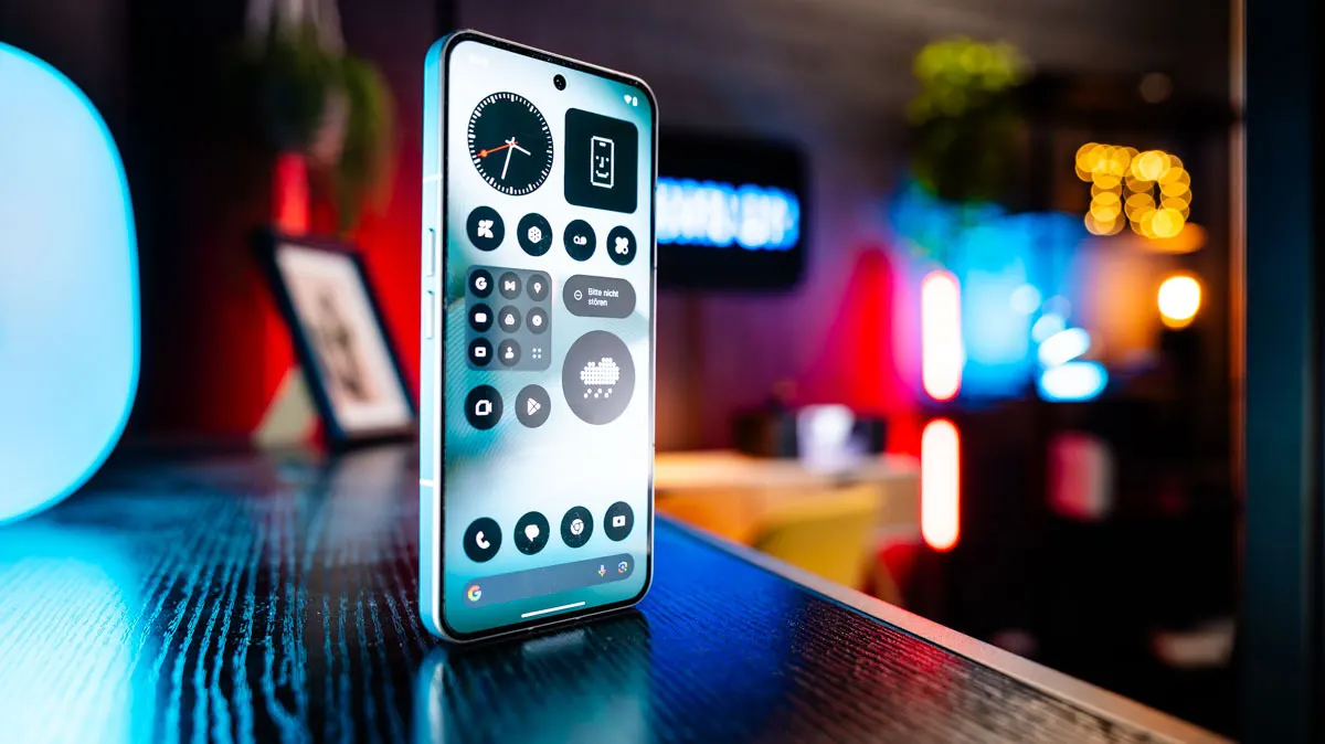 Das Nothing Phone (3) steht mit eingeschaltetem Display auf einem schwarzen Tisch.