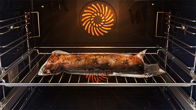 Egy zsugorfóliába csomagolt húsdarab a levegőben sous vide eljárással.