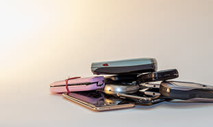 Mehrere alte Handys und Smartphones liegen auf einem Stapel.