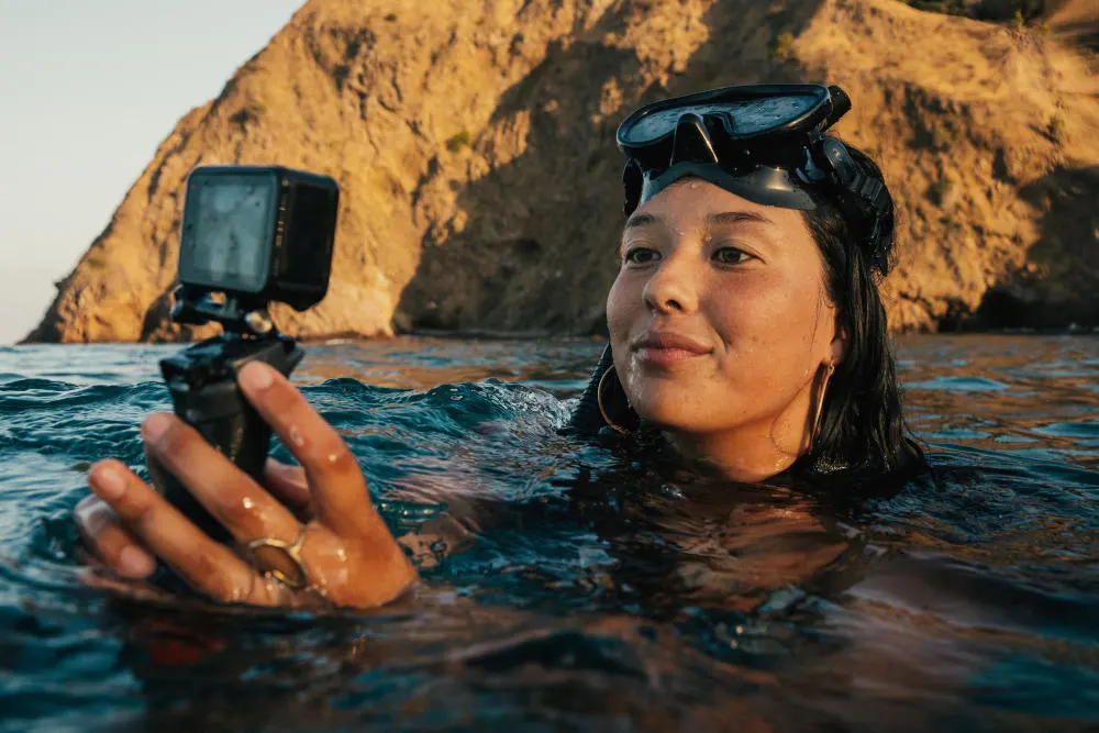 Frau_taucht_mit_GoPro_Hero11_Black_aus_dem_Wasser_auf