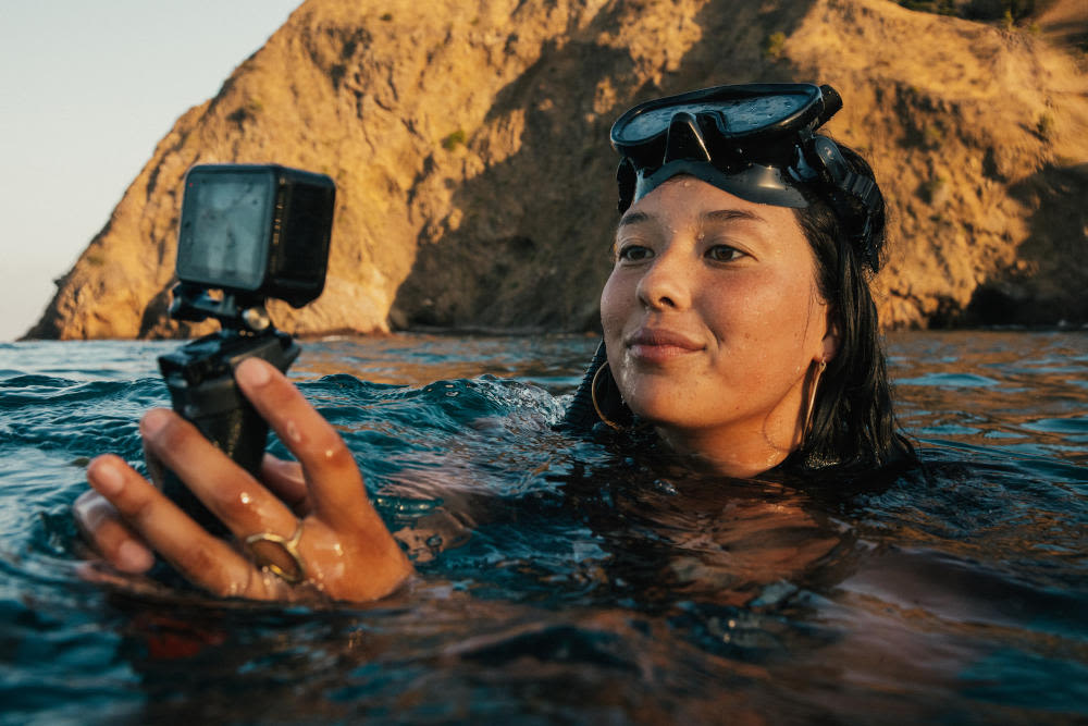 Frau taucht mit GoPro Hero11 Black aus dem Wasser auf