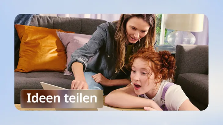 Eine Frau und ein Kind schauen auf einen Laptop. Sie sitzen auf einem grauen Sofa mit orangefarbenen und rosa Kissen.