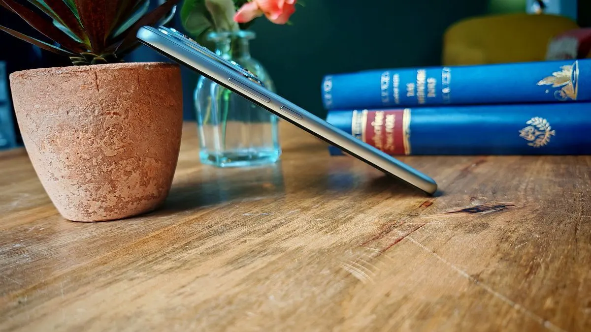 Der dicke Rahmen des Honor 400 Pro ist zu sehen, während das Smartphone an einer Blumenvase lehnt.