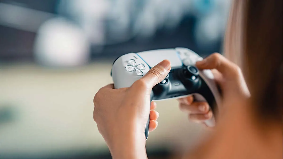 Zwei Hände halten einen weißen PS5-Controller.