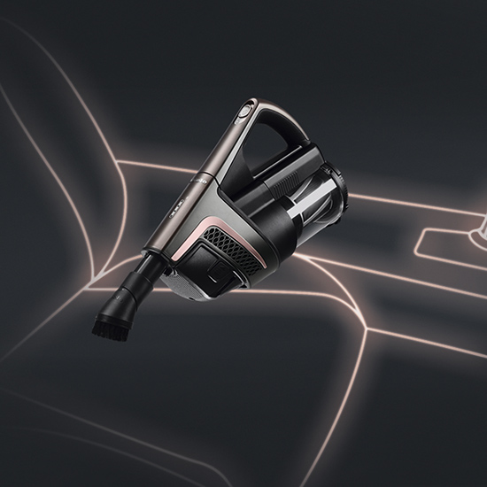 Ein Akku-Staubsauger mit Griff und durchsichtigem Behälter liegt vor einem dunklen Hintergrund mit hellen Linien.