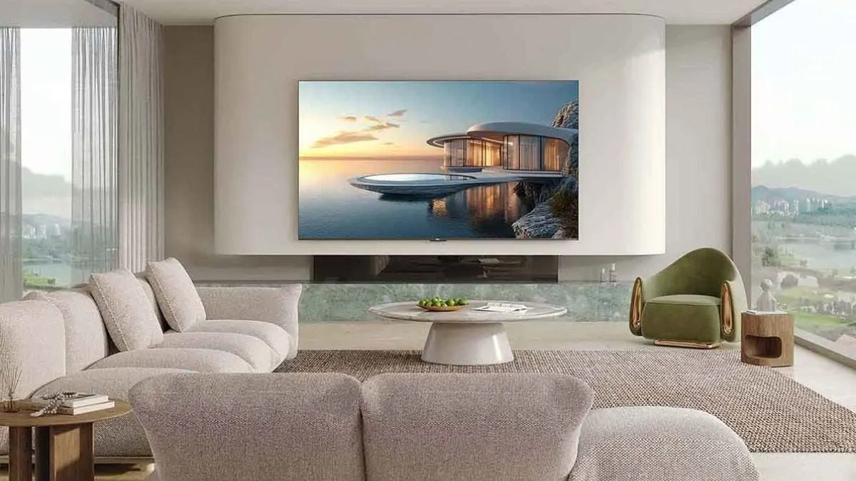 Der Fernseher TCL C7K hängt an einer Wand in einem hellen Wohnzimmer.