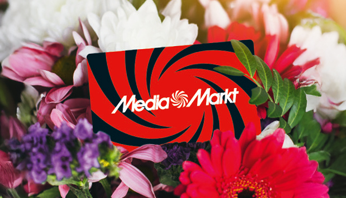 MediaMarkt Geschenkkarte mit rotem Wirbel-Design liegt zwischen bunten Blumen, ideal als Geschenk.
