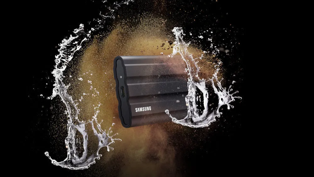 Ein schwarzes Samsung-Gerät ist inmitten von Wasser- und Staubexplosionen vor einem schwarzen Hintergrund zu sehen.