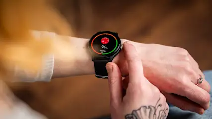 Eine Person mit einer schwarzen Smartwatch am Handgelenk, die 94% auf dem Display anzeigt.