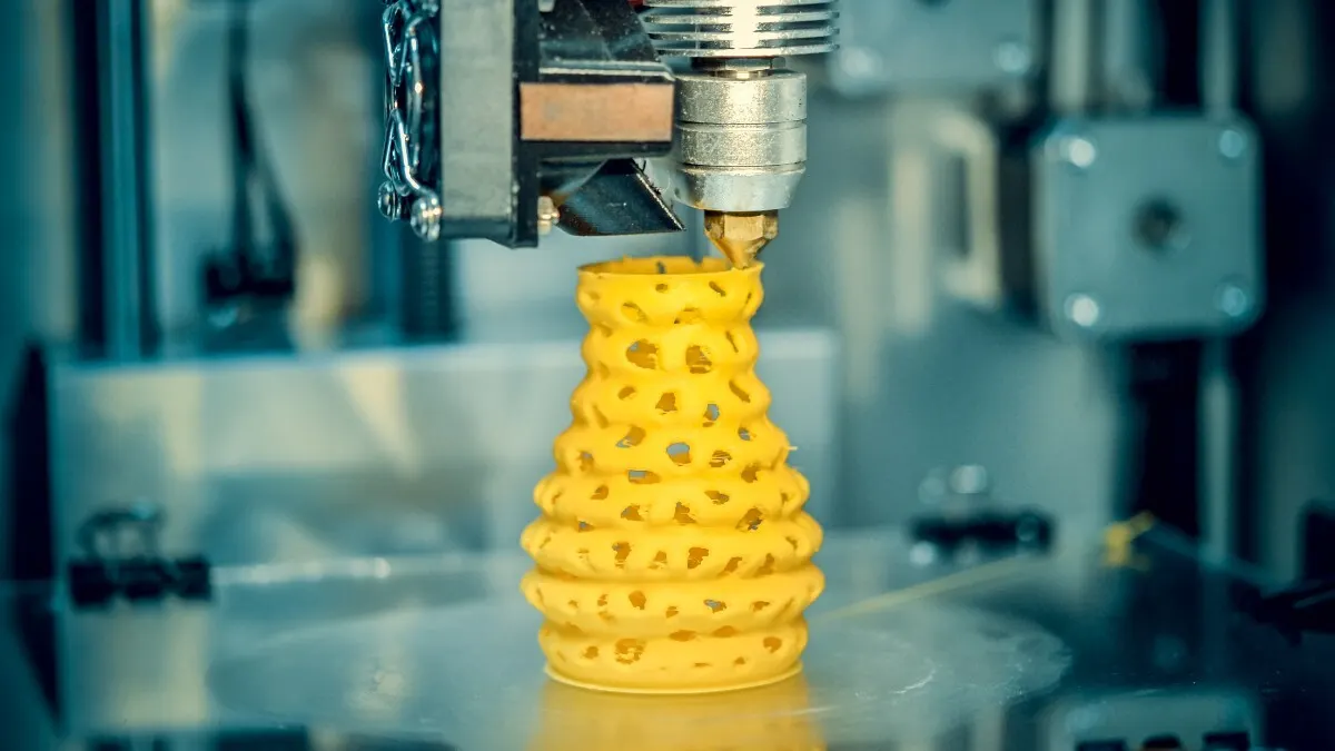 Ein 3D-Drucker druckt ein gelbes Modell.