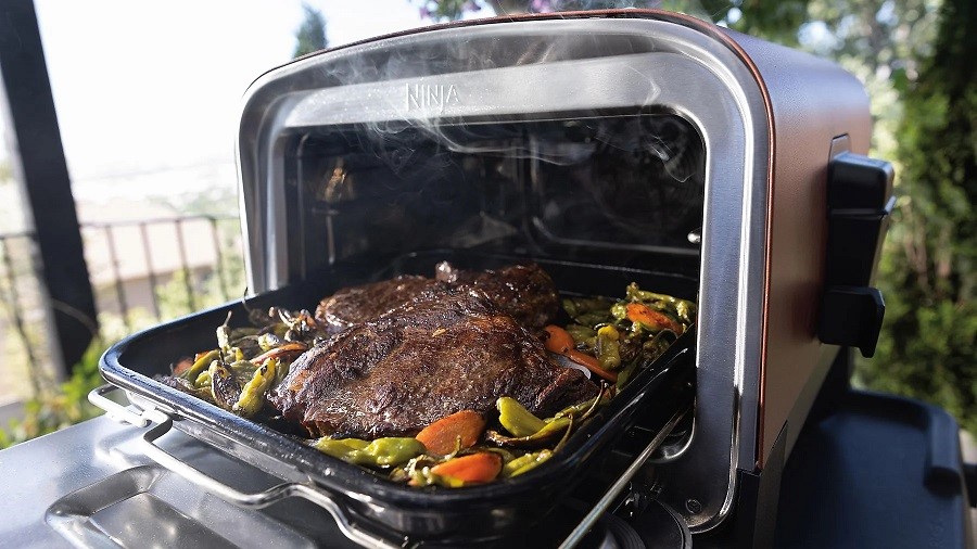 Der NINJA OO101EU Woodfire Outdoor Oven Elektrogrill verfügt über einen verstellbaren Grillrost.