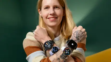 Franzi überkreuzt beide Arme vor dem Oberkörper. Sie trägt an jedem Unterarm zwei Smartwatches.