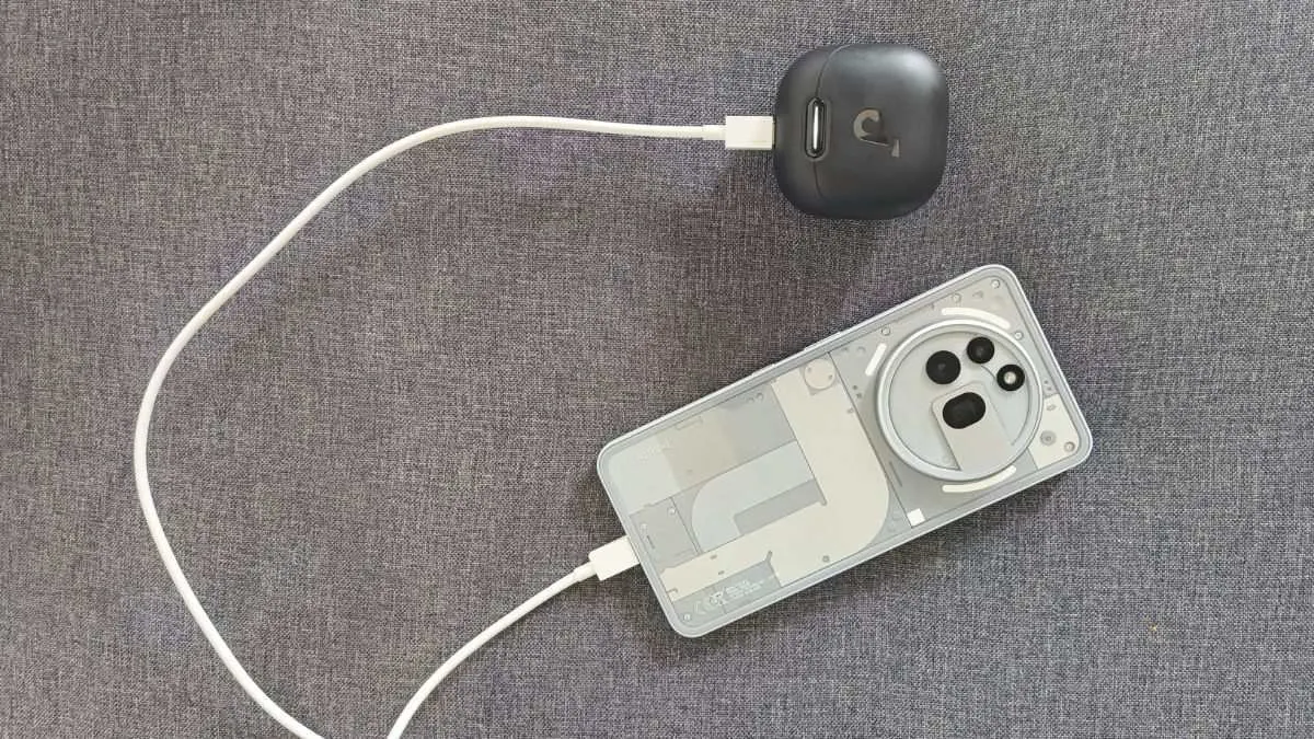 Das Nothing Phone (3a) Pro lädt ein Bluetooth-Kopfhörer-Ladecase über ein weißes Kabel auf.