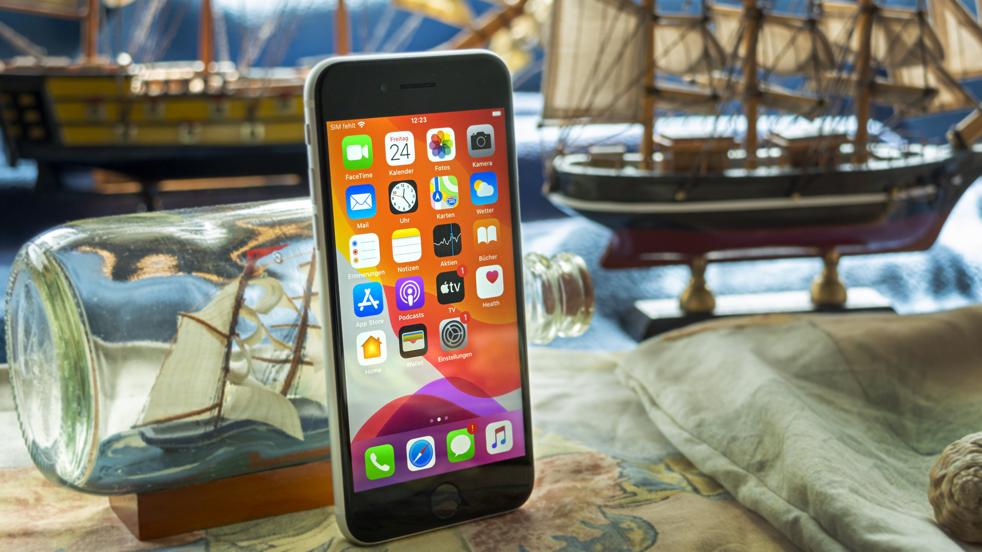 Das iPhone SE (2020) steht vor einem Buddelschiff.