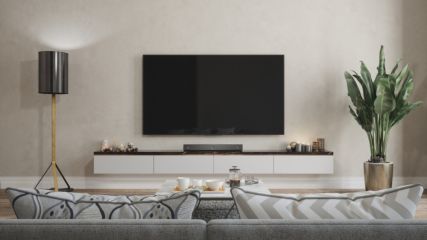 Ein Fernseher hängt in einem Wohnzimmer an der Wand.
