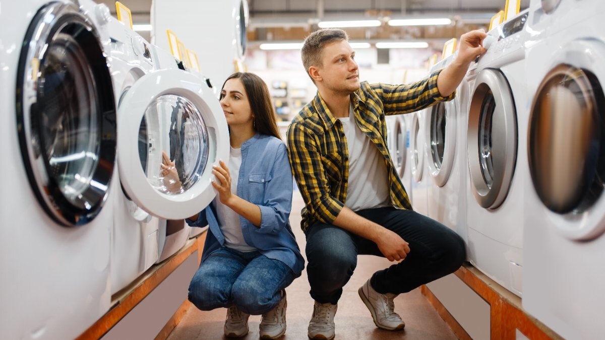 Eine Frau und ein Mann schauen sich im Fachhandel Waschmaschinen an.