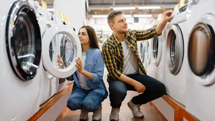 Eine Frau und ein Mann schauen sich im Fachhandel Waschmaschinen an.