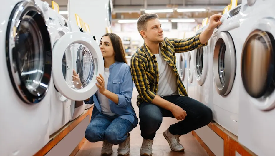 Eine Frau und ein Mann schauen sich im Fachhandel Waschmaschinen an.