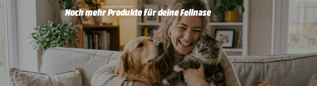Lächelnde Frau sitzt auf einem Sofa und kuschelt mit einem Golden Retriever und einer grau-getigerten Katze. Im Bild steht: „Noch mehr Produkte für deine Fellnase“ sowie der Button „Zu den Produkten“.