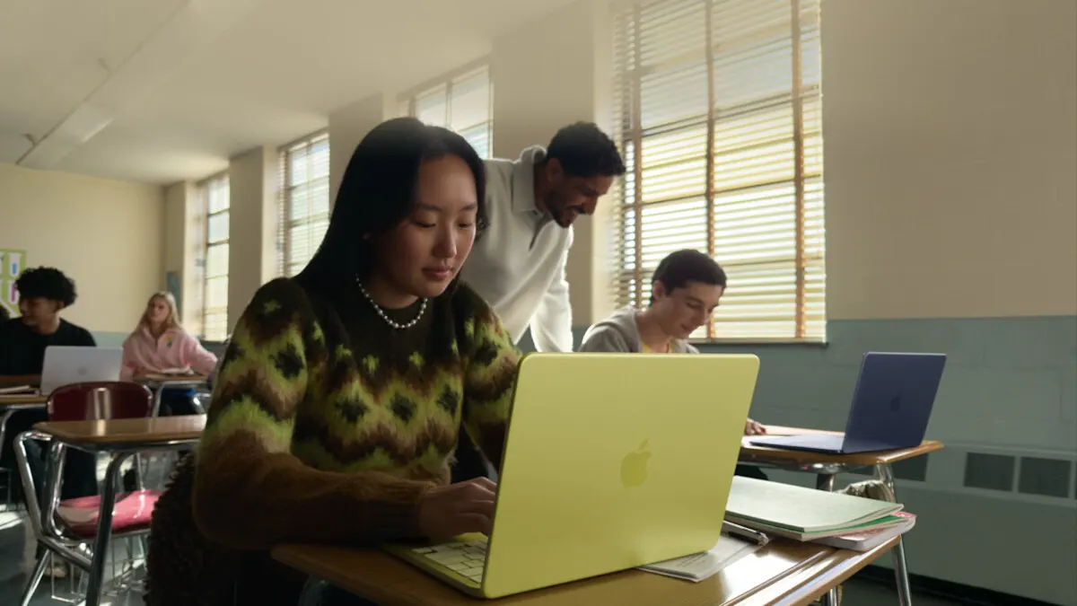 Eine junge Frau tippt in der Schule auf der Tastatur des MacBook Neo.