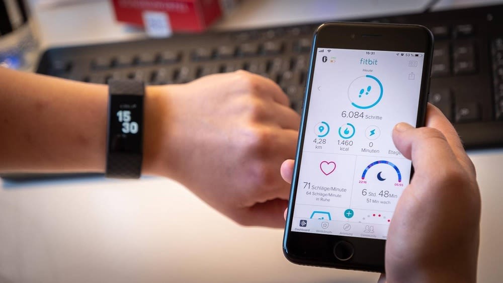 Nutzer mit schwarzer Fitbit Charge 3 um das Handgelenk kontrolliert Schritte in der Fitbit App.
