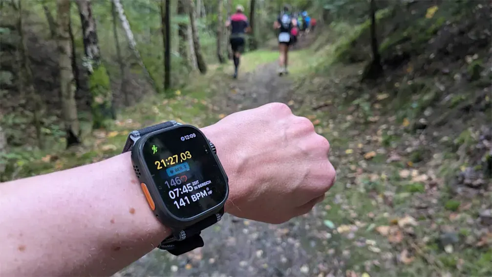 Franzi trägt die Smartwatch Apple Watch Ultra während eines Trail Runs in einem Wald.