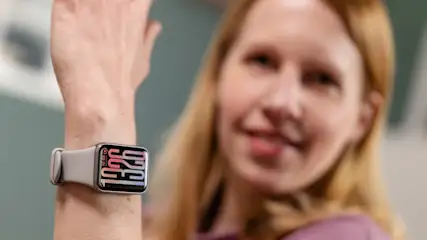 Franzi trägt das Xiaomi Smart Band 9 Pro am linken Handgelenk und hält den Arm hoch.