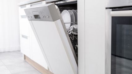Geöffnete Geschirrspülmaschine in einer weißen Küche