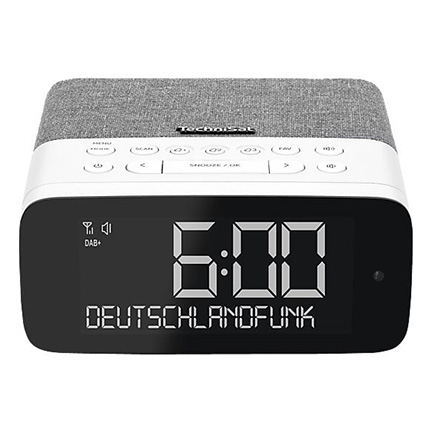 Kompakter DAB+ Radiowecker in Weiß/Grau mit Stoffoberseite, großen 6:00 Ziffern und Tasten oben; Display zeigt „DEUTSCHLANDFUNK“.