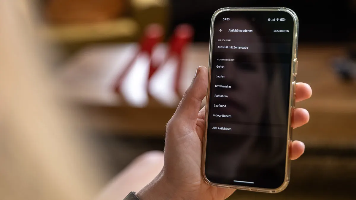Franzis Hand hält ihr Smartphone, das die Aktivitäten in der Connect-App zeigt, die auf die Taste am Garmin Cirqa gelegt werden können.