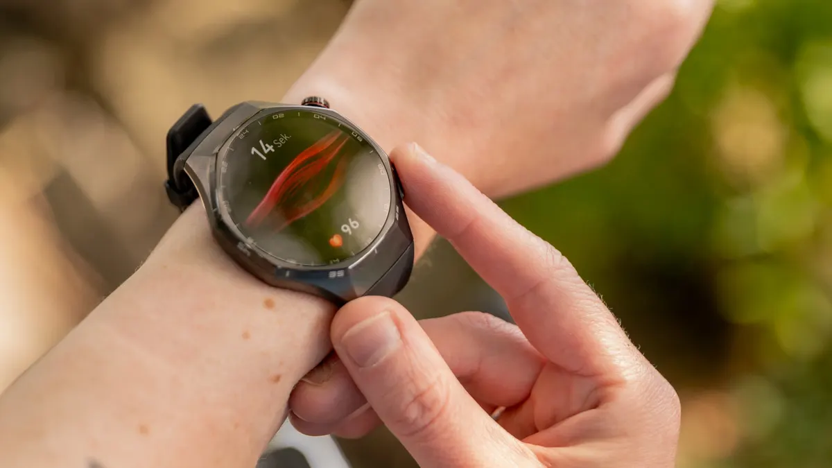 Franzi misst die arterielle Steifigkeit mit der Huawei Watch GT 6 Pro, indem sie ihren rechten Zeigefinger auf die untere Taste legt.