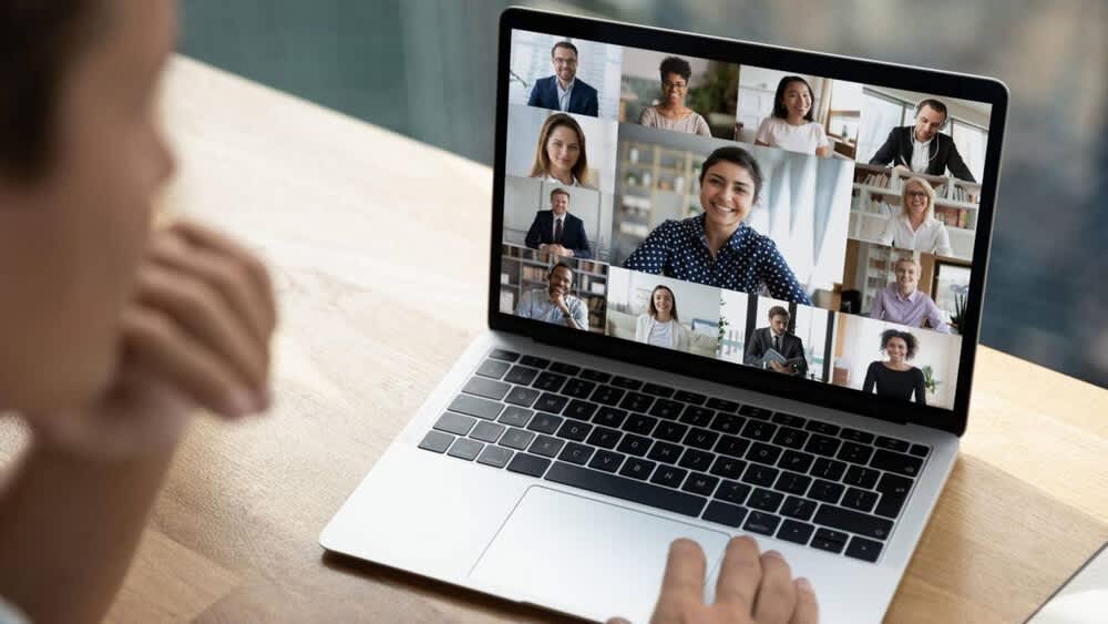 Eine Person nimmt über ein MacBook an einem Zoom-Meeting teil.